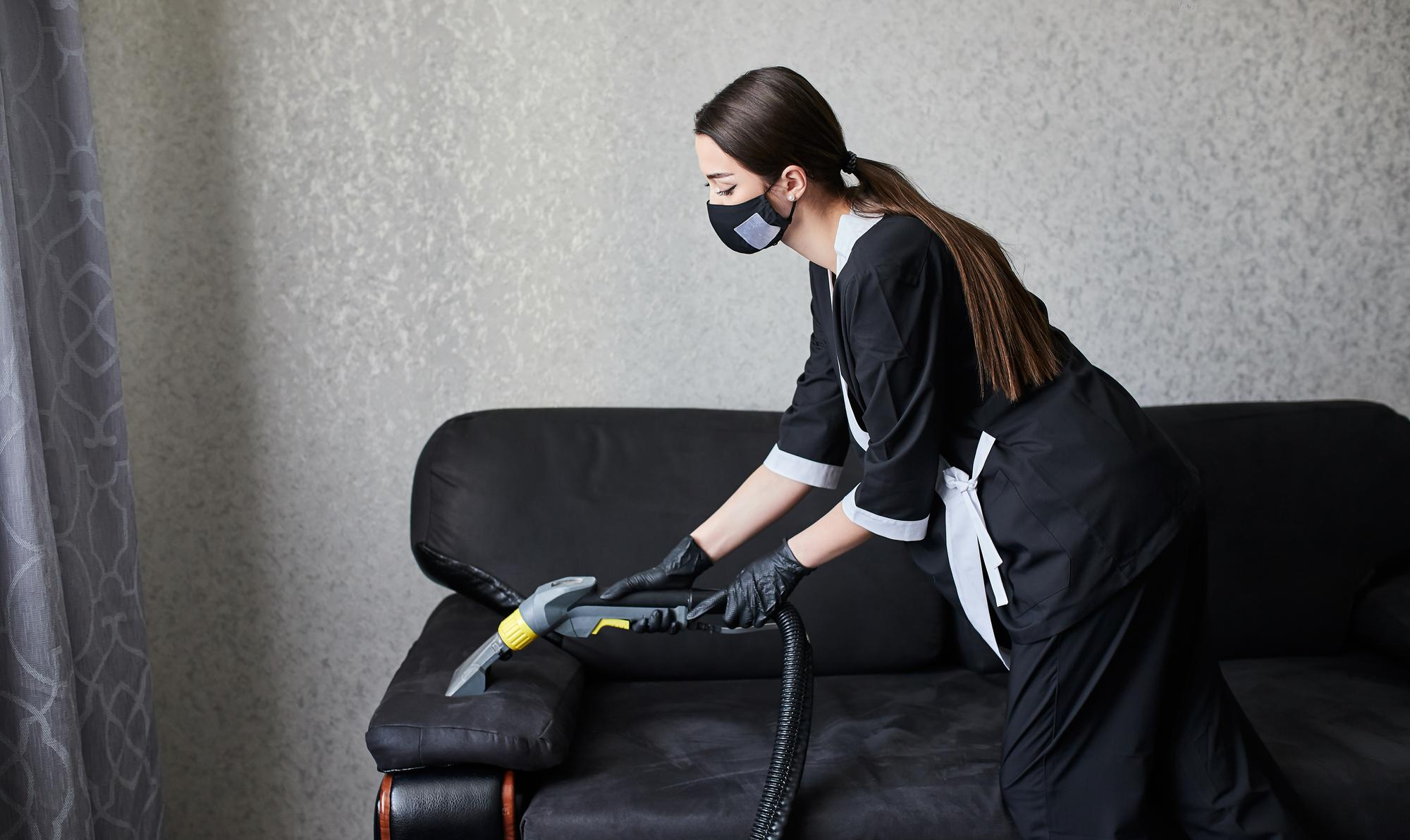 Primo piano della pulizia con un macchinario a iniezione-estrazione per la rimozione di una macchia dal bracciolo di una poltrona